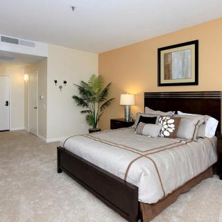 A modern bedroom with a large bed, neutral tones, and stylish decor.