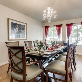 A beautifully decorated dining room with a large table, elegant chairs, and a chandelier.