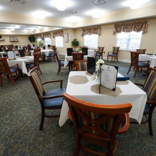 A spacious dining room with neatly arranged tables and chairs.