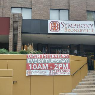 A sign outside a building advertising open interviews every Tuesday from 10 AM to 2 PM.