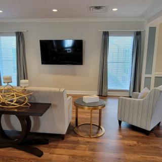 A contemporary living room with a wall-mounted television, comfortable seating, and elegant decor.