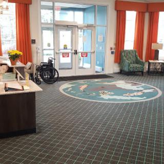 A welcoming lobby featuring a decorative carpet, comfortable seating, and accessibility options.