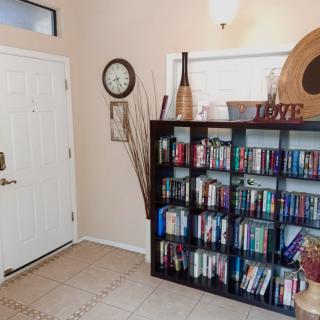 A cozy entryway featuring a bookshelf filled with books and various home decor items.