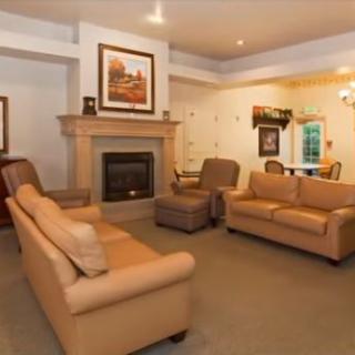 A cozy living room featuring a fireplace, sofas, and armchairs.