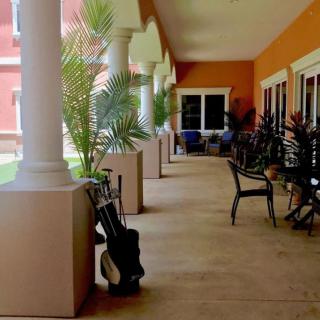 A veranda with outdoor seating and potted plants.
