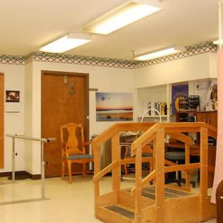 A rehabilitation room equipped with wooden stairs and parallel bars for physical therapy exercises.