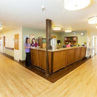 A welcoming reception area in a healthcare facility, featuring staff members at the front desk.