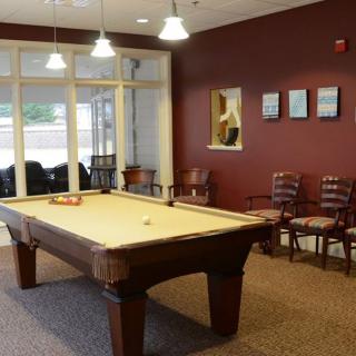 A cozy game room with a pool table and seating area.