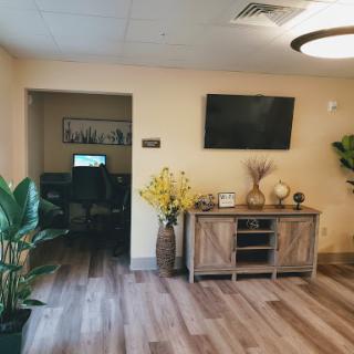 A welcoming lobby area featuring modern decor, plants, and a television for guests.