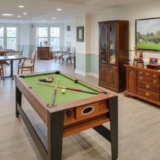 A well-appointed game room featuring a pool table and classic wooden furniture.
