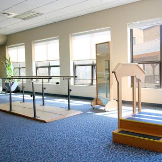 A bright physical therapy room equipped with rehabilitation tools and ample natural light.