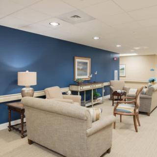 A modern lounge area with sofas, chairs, and a blue accent wall.