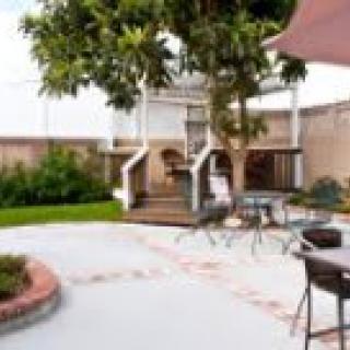 A well-maintained backyard with a patio, outdoor furniture, and a grill.