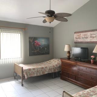 A cozy bedroom featuring twin beds, a ceiling fan, and tasteful decor.