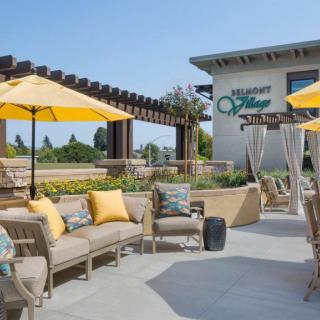 A sunny patio with comfortable outdoor seating and yellow umbrellas.