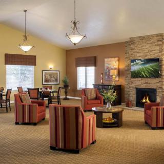 A cozy living room with armchairs, a fireplace, and warm lighting.
