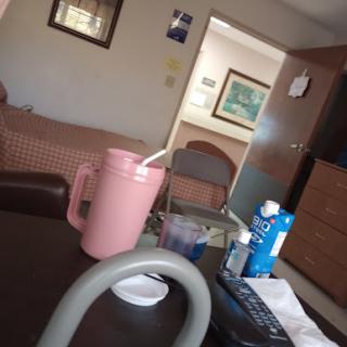 A cozy living room setting with a pink pitcher and various items on the table.