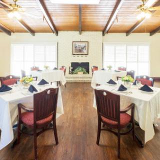 A beautifully arranged dining room featuring elegantly set tables and warm wooden accents.