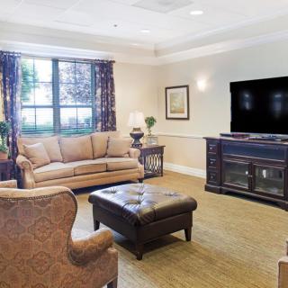 A cozy living room with a sofa, armchair, coffee table, and television.
