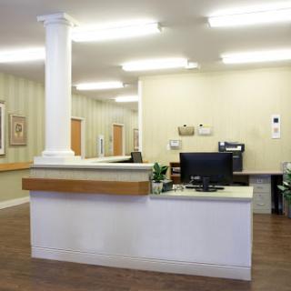 A modern medical reception area featuring a front desk and well-lit surroundings.