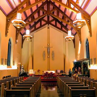 A serene view of the interior of a church featuring wooden beams and elegant lighting.