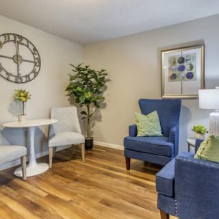 A cozy living room with stylish armchairs, a wooden floor, and tasteful decor.