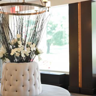 A luxurious lobby interior with a tufted seating area and elegant floral arrangement.