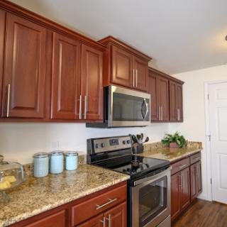 A modern kitchen featuring rich wooden cabinets and sleek stainless steel appliances.
