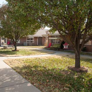 A suburban house with a front yard and trees in an autumn setting.