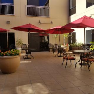 A serene outdoor patio space featuring red umbrellas and comfortable seating, perfect for relaxation.