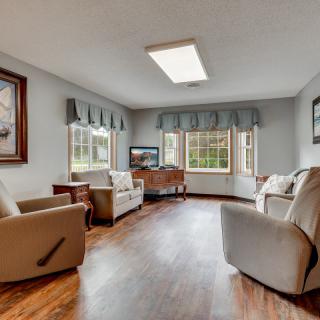 A cozy living room with plush armchairs and large windows, featuring hardwood floors and tasteful decor.