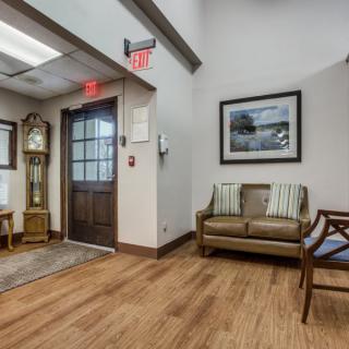 A well-furnished lobby area with comfortable seating and a decorative clock.