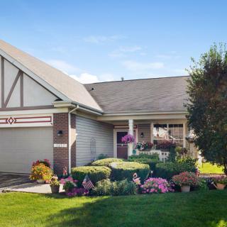 A charming suburban house with a well-maintained garden and lush green lawn.