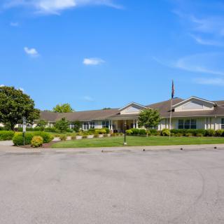 A single-story building surrounded by landscaping under a clear blue sky.