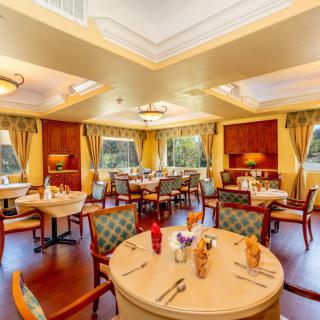A cozy and elegantly decorated dining area with neatly arranged tables and chairs.