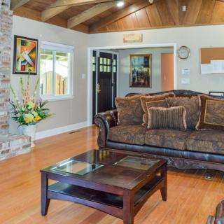 A cozy living room with a brown sofa, glass-top coffee table, and a brick fireplace.