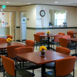 A well-organized dining area with multiple tables and chairs, decorated with sunflower centerpieces.