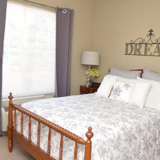 A cozy bedroom with a wooden bed frame and elegant decor.