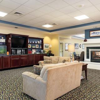 A cozy living room with a sofa, entertainment center, and fireplace.