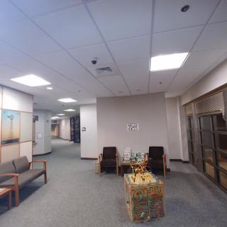A spacious office waiting area featuring chairs and a small table.