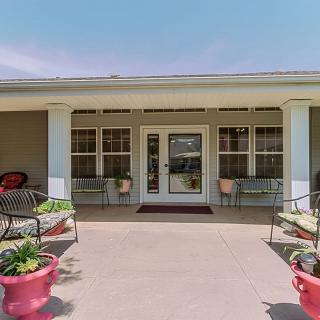 A welcoming entrance with columns, seating, and decorative planters.