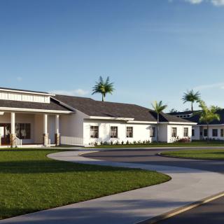 A modern residential house with a spacious lawn and driveway under a clear blue sky.