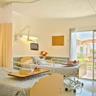 A bright and welcoming hospital patient room with modern furnishings and natural light.