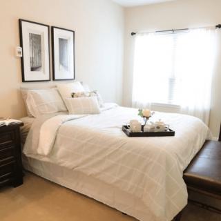 A minimalist bedroom with a neatly made bed and simple decor.