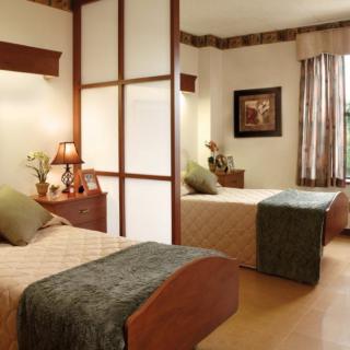 A cozy bedroom featuring two single beds with elegant decor and ample natural light.