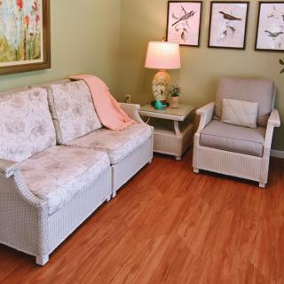 A cozy living room with a sofa, armchair, and decorative wall art.