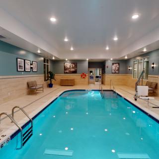 An inviting indoor swimming pool with ambient lighting and seating areas.