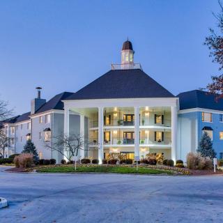 A grand hotel with lighted windows and a welcoming entrance at twilight.
