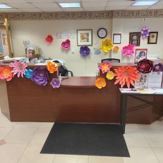A vibrant and welcoming reception area adorned with colorful paper flower decorations.