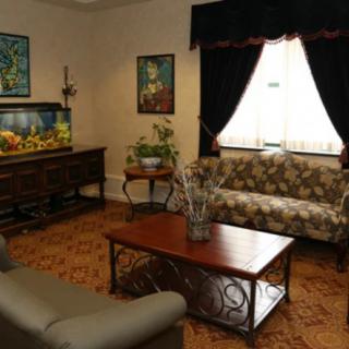 A cozy living room with a sofa, coffee table, and an aquarium.